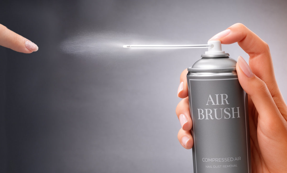 Dłoń psika sprężonym powietrzem AIR BRUSH w stronę paznokcia